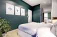 Aranżacja sypialni z mocnym zielonym kolorem na ścianie