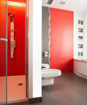 Czerwona łazienka z prysznicem i wanną.