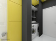 Łazienka z żółta ścianą oraz z pralką i suszarką