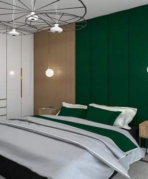 Sypialnia z meblami w zabudowie z intensywną zielenią na ścianie