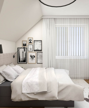 Sypialnia ze skosami sufitowymi z szafą z białymi frontami
