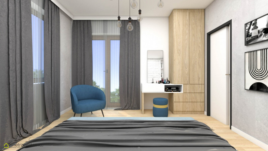 Przestrzenna sypialnia z łóżkiem kontynentalnym oraz z niebieskim fotelem
