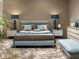 Sypialnia z niebieskim łóżkiem i dużą pufą