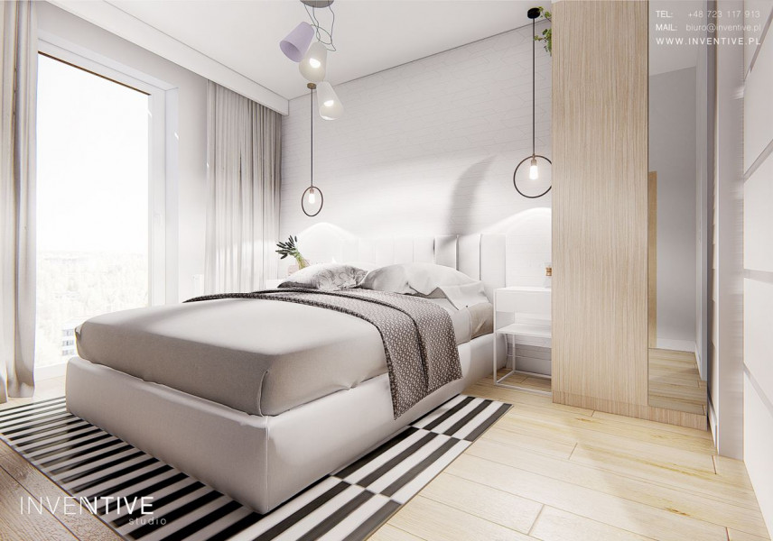 Sypialnia z łóżkiem kontynentalnym oraz z jasnymi panelami podłogowymi