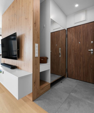 Salon z drewnianą ścianą i zamontowanym telewizorem do niej