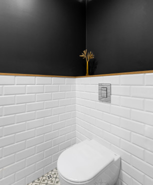 Łazienka z białymi płytkami oraz czarną ścianą