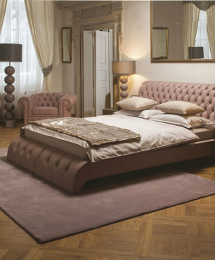 Sypialnia z tapicerowanym łóżkiem oraz sofą i fotelem