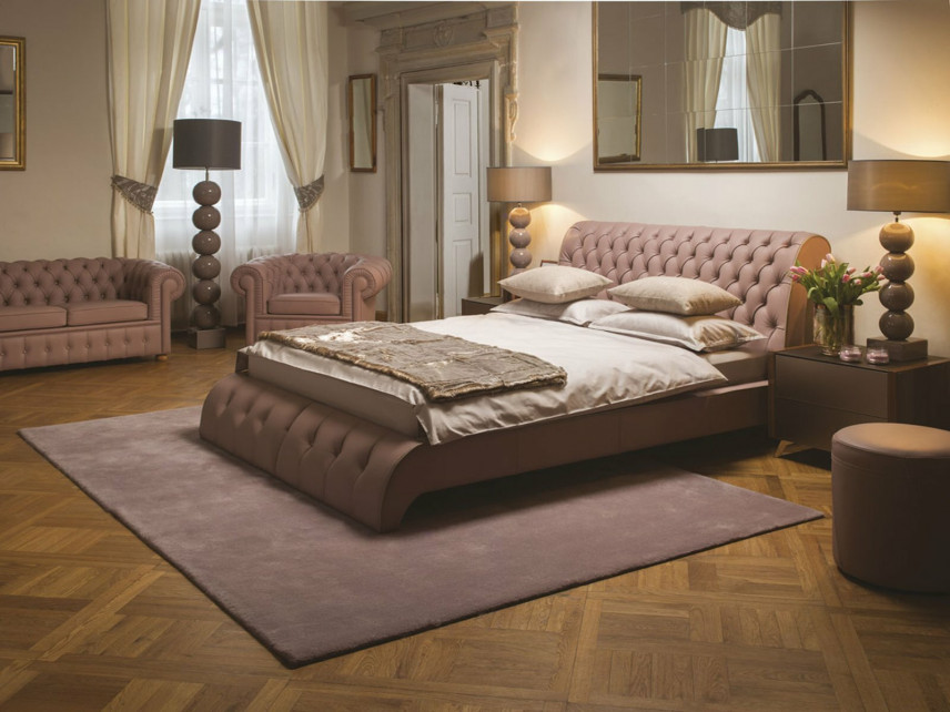 Sypialnia z tapicerowanym łóżkiem oraz sofą i fotelem