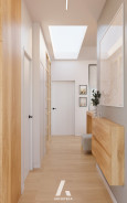 Wąski, biały korytarz z drewnianą komodą