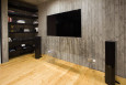 Salon z drewnianą podłogą oraz drewnianą boazerią na ścianie