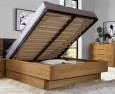 Nowoczesna sypialnia z dużym, drewnianym łóżkiem kontynentalnym z funkcją przechowywania