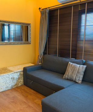Salon z granatową kanapą i żółtą ścianą
