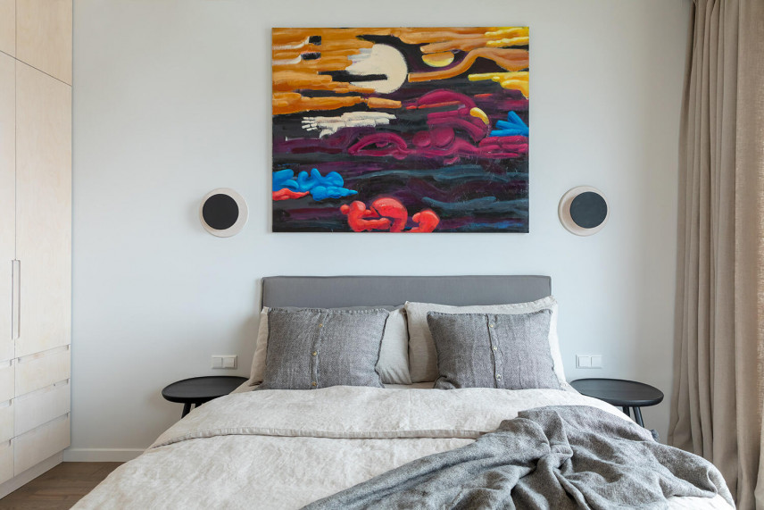 Sypialnia z kolorowym obrazem na ściennie oraz z łóżkiem kontynentalnym