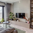 Salon z tynkiem o wyglądzie betonu i telewizorem zamontowanym do ściany