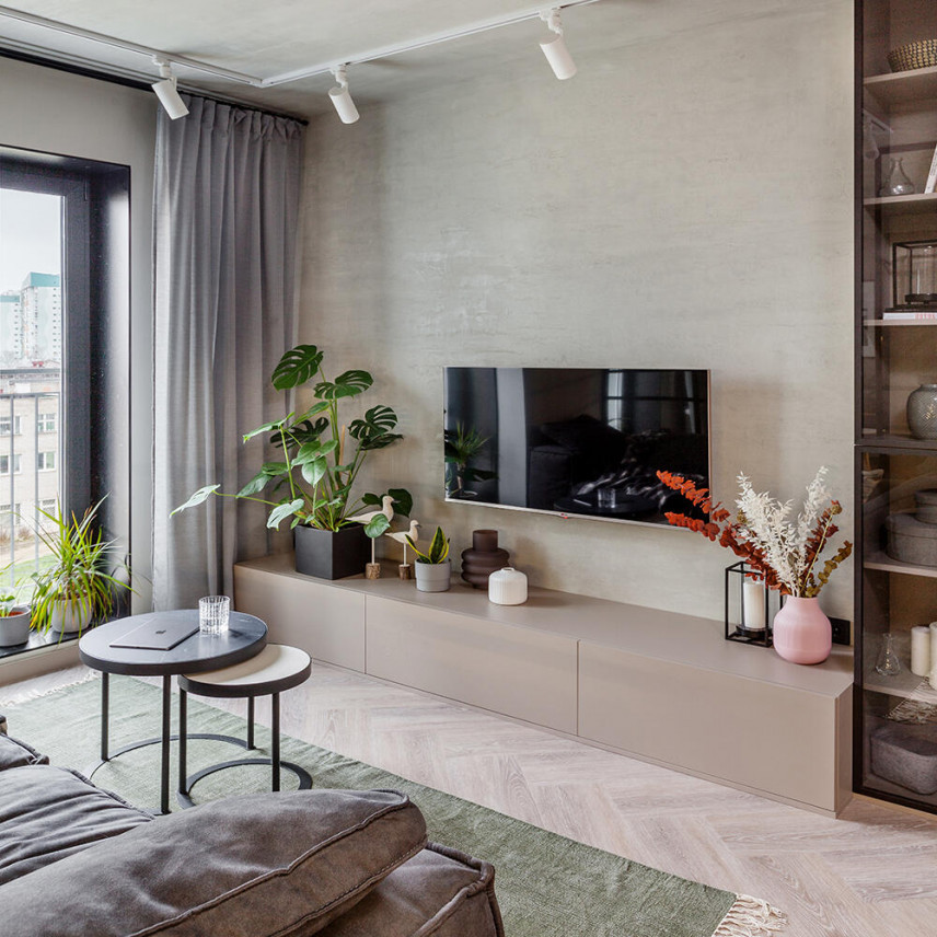 Salon z tynkiem o wyglądzie betonu i telewizorem zamontowanym do ściany