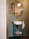 Łazienka z okrągłym lustrem zamontowanym na ścianie