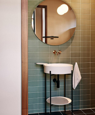 Łazienka z okrągłym lustrem zamontowanym na ścianie