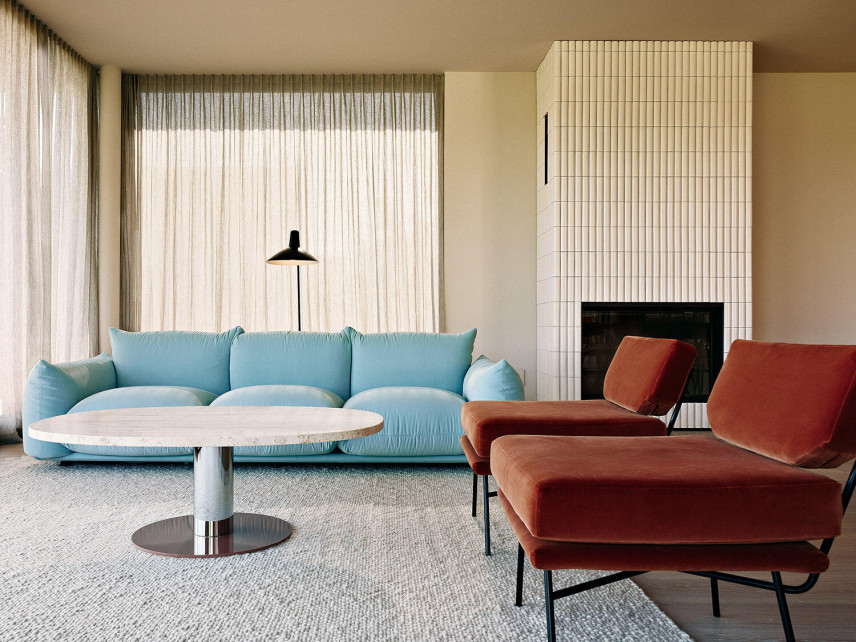Salon z niebieską sofą oraz bordowymi fotelami