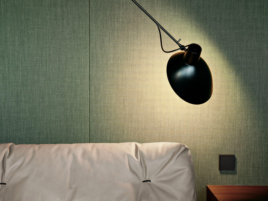 Zielona ściana w sypialni z lampą montowaną do sufitu