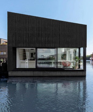 Dom holenderski na wodzie z zabarwionym na czarno drewnem