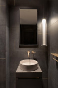Łazienka w stylu industrialnym ze złotą  armaturą łazienkową
