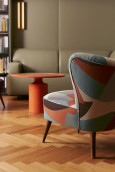 Nowoczesny salon ze skórzaną sofą oraz kolorowym fotelem uszak