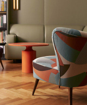 Nowoczesny salon ze skórzaną sofą oraz kolorowym fotelem uszak