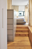 Sypialnia z drewnianymi schodami i łóżkiem kontynentalnym