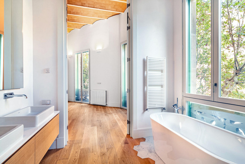 Łazienka z dużym oknem oraz drewnianymi panelami