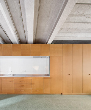 Duża kuchnia z meblami z brązowym frontem oraz z betonowym sufitem