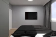 Projekt małej sypialni z telewizorem na szarej ścianie