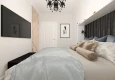 Sypialnia z czarnym żyrandolem i dużym łóżkiem kontynentalnym