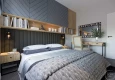 Projekt sypialni z dużym łóżkiem oraz tapicerowaną ścianą z szafką wiszącą nad łóżkiem