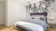 Projekt sypialni z tapetą na ścianie oraz kryształowym żyrandolem