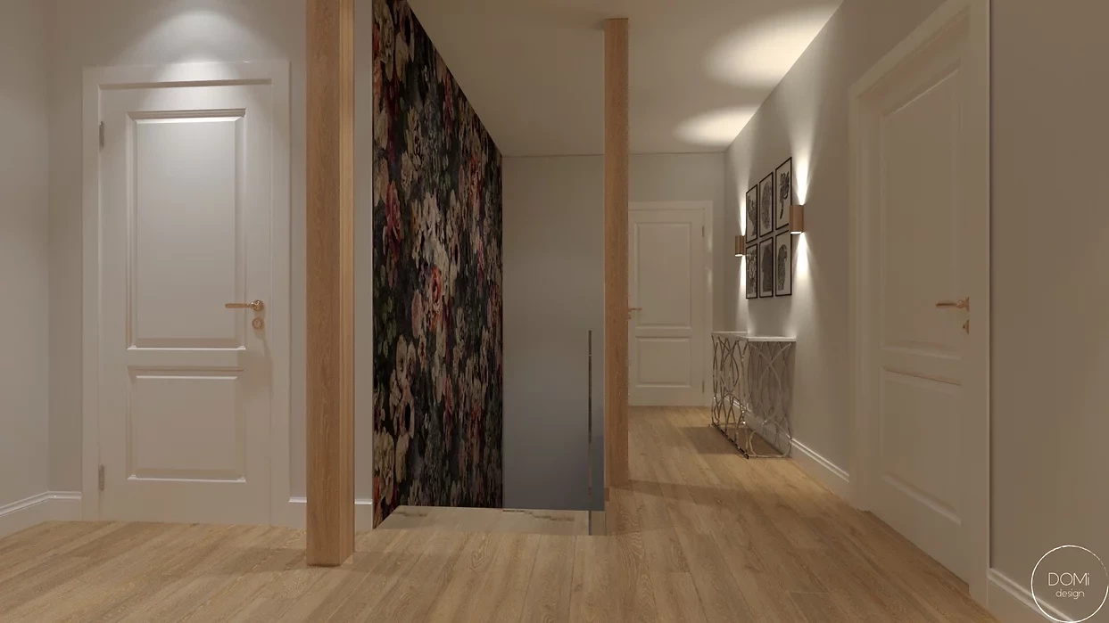 Wąski korytarz z tapetą w kwiaty na ścianie oraz ze schodami