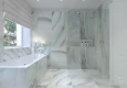 Projekt łazienki z wanną w zabudowie i prysznicem oraz armaturą łazienkową w kolorze złotym