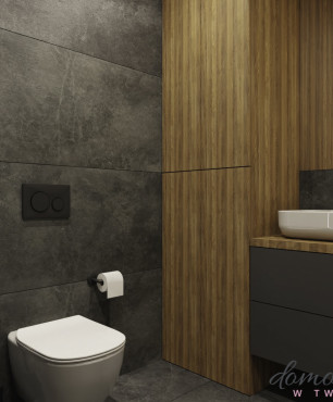 Mała łazienka z dużymi szarymi płytkami na ścianie i podłodze