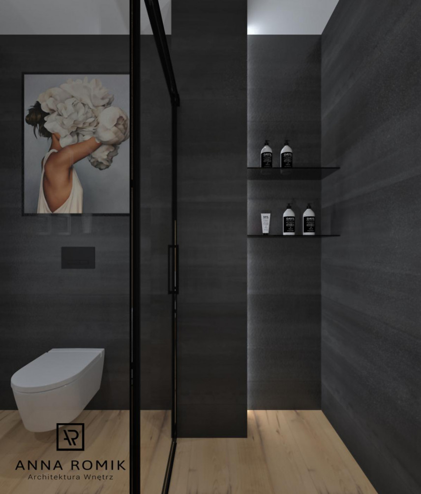 Projekt łazienki z czarnymi, jednolitymi płytkami na ścianie oraz z obrazem