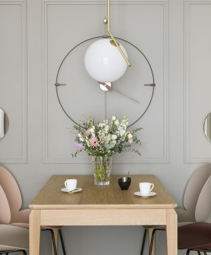 Projekt jadalni z okrągłymi lustrami ozdobnymi na ścianie oraz dużym zegarem