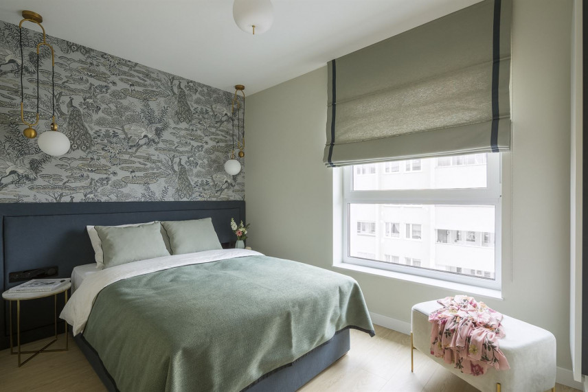 Projekt sypialni z tapetą na ścianie, z łóżkiem kontynentalnym tapicerowanym oraz stylowym pufem