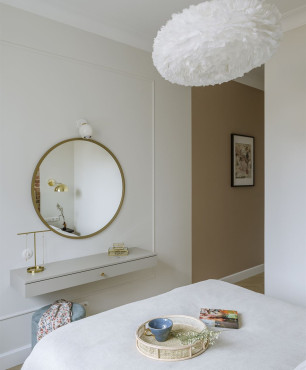 Sypialnia z toaletką z okrągłym lustrem zamontowanym na białej ścianie