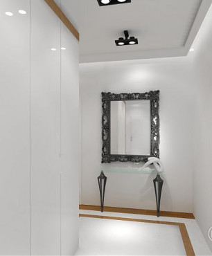 Korytarz z białą szafą w głębokim połysku oraz z pięknym lustrem na ścianie