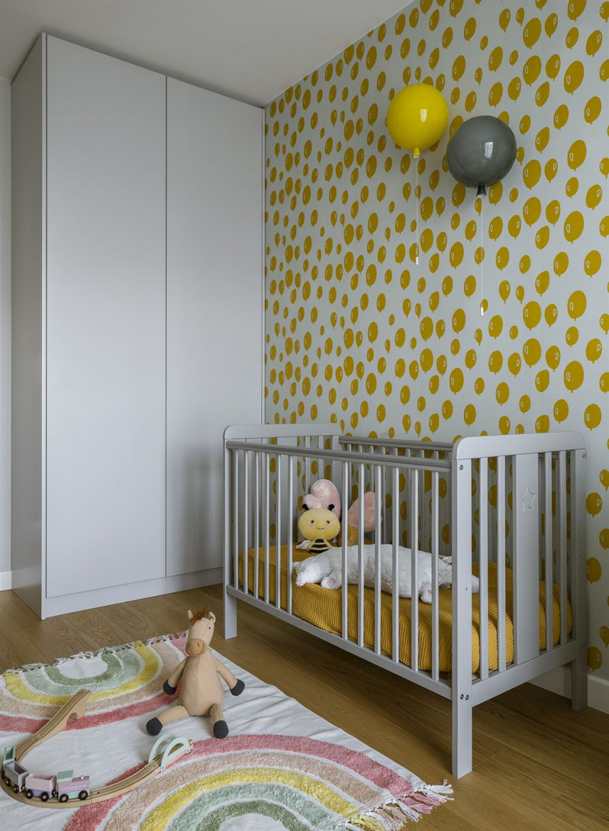Przytulny pokój dziecięcy z łóżeczkiem dla noworodka oraz białą szafą