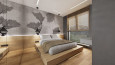 Sypialnia z drewnianym łóżkiem kontynentalnym oraz szarą tapetą na ścianie
