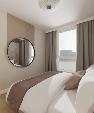 Sypialnia z okrągłym lustrem w czarnej ramie oraz z łóżkiem kontynentalnym