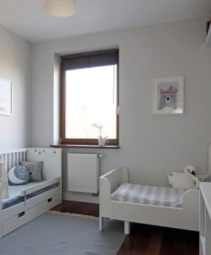 Pokój dziecięcy z dwoma białymi łóżeczkami oraz podłogą w kolorze wenge
