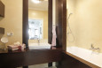 Klasyczna łazienka z brązową szafką wiszącą oraz wanną w brązowej zabudowie