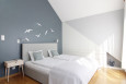 Sypialnia na poddaszu z niebieską ścianą oraz naklejkami