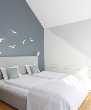 Sypialnia na poddaszu z niebieską ścianą oraz naklejkami