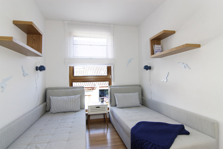 Sypialnia z drewnianymi półkami mocowanymi do ściany